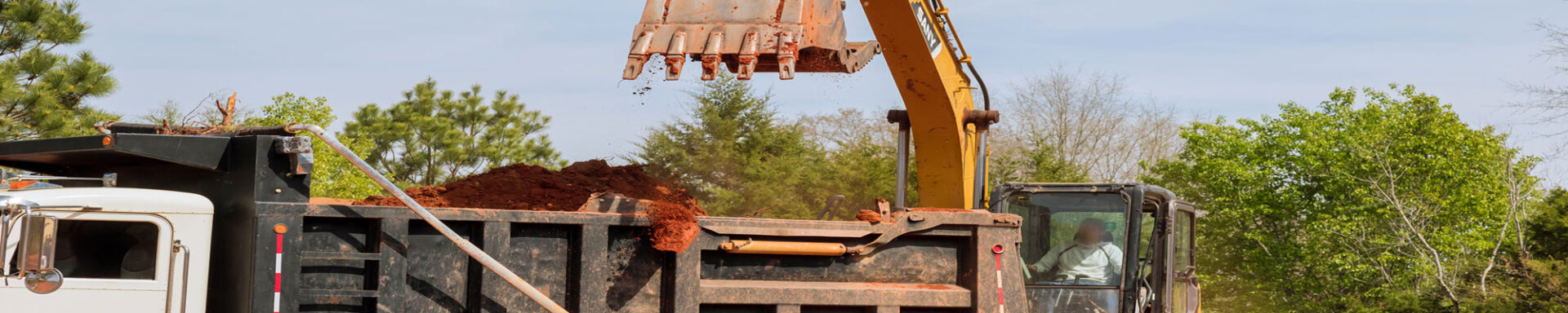 Backhoe putting dirt into Truck