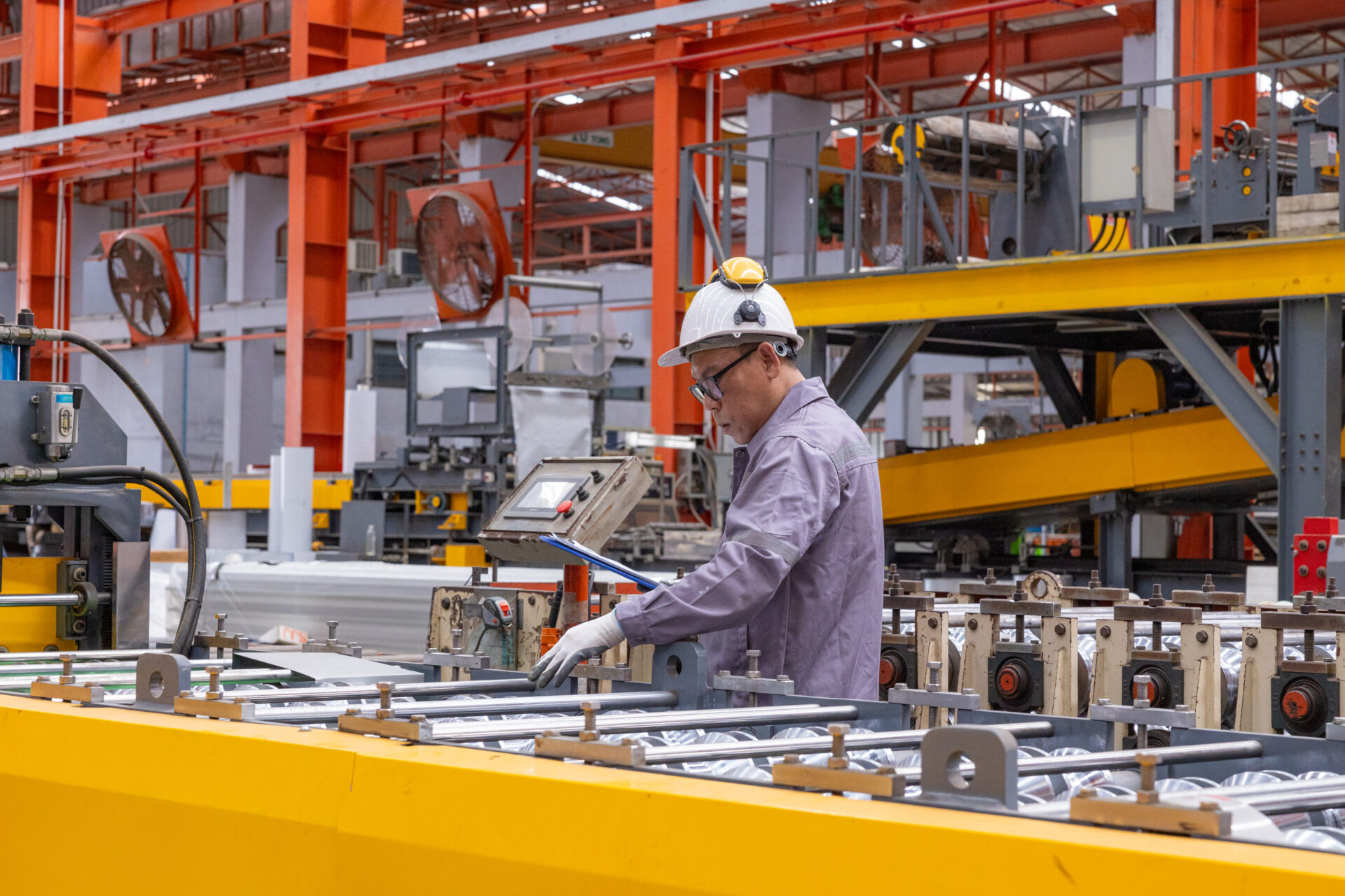 Engineers Overseeing Metal Sheet Production In Factory